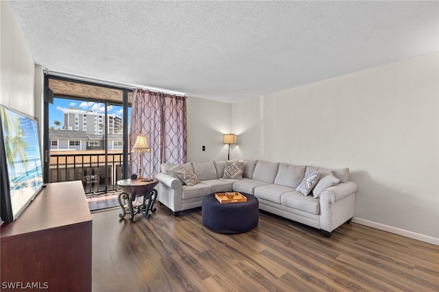 living room featuring a textured ceiling, dark hardwood / wood-style flooring, and a wall of windows