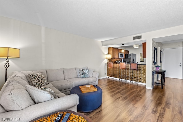 living room featuring a textured ceiling and hardwood / wood-style flooring