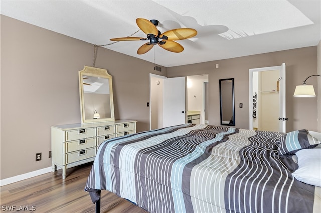 bedroom featuring a walk in closet, ceiling fan, and wood-type flooring