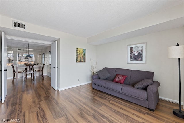 living room featuring dark hardwood / wood-style floors and a textured ceiling