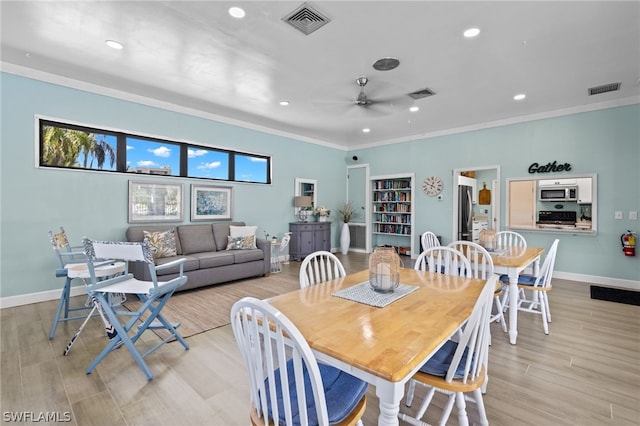 dining space with ceiling fan, light hardwood / wood-style flooring, and crown molding