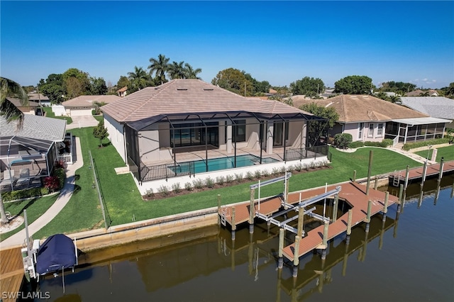 back of house with a lanai, a yard, a water view, and a patio