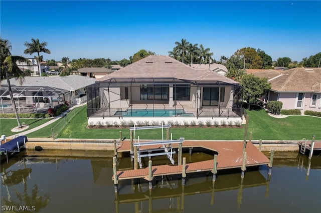 back of house with a yard, a water view, and glass enclosure