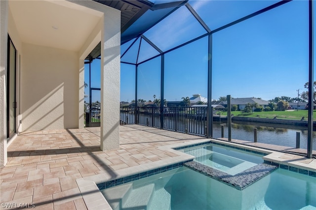 view of swimming pool with an in ground hot tub, a patio, a water view, and glass enclosure