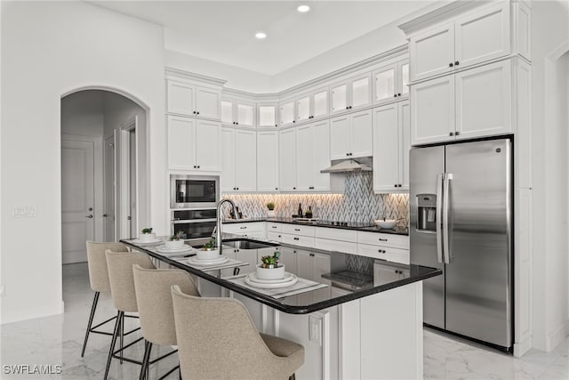 kitchen with a breakfast bar, sink, white cabinets, and stainless steel appliances