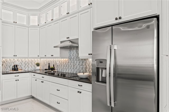 kitchen with white cabinets, stainless steel fridge, tasteful backsplash, and black cooktop