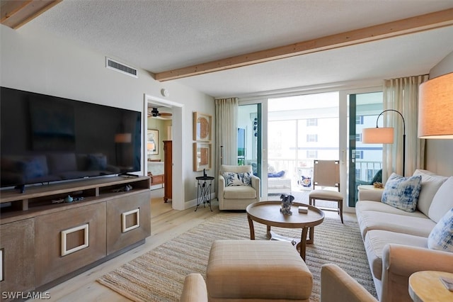 living room featuring a textured ceiling, ceiling fan, and light hardwood / wood-style flooring