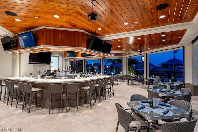 bar with wooden ceiling, a mountain view, and light tile floors