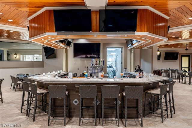 kitchen featuring a kitchen breakfast bar, wooden ceiling, and light tile flooring