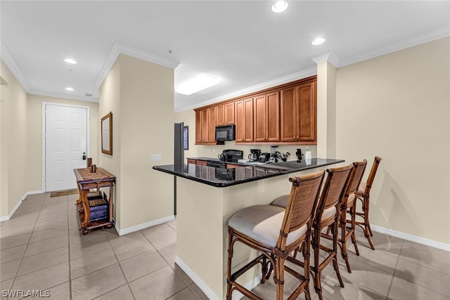 kitchen featuring kitchen peninsula, black appliances, light tile flooring, a kitchen bar, and ornamental molding