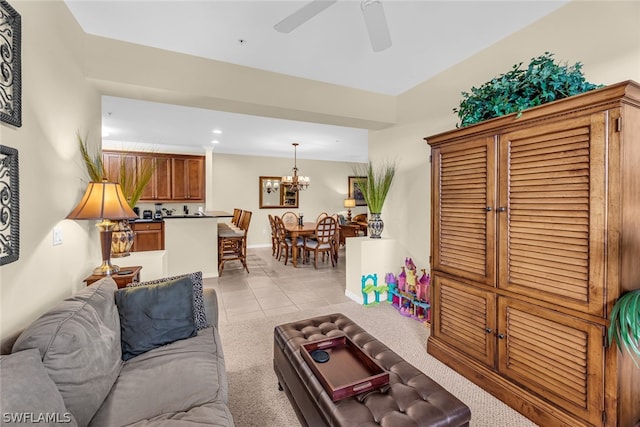 tiled living room featuring ceiling fan with notable chandelier