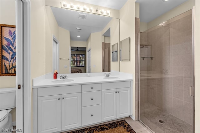 bathroom featuring toilet, an enclosed shower, and dual bowl vanity