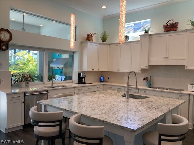 kitchen with pendant lighting, light stone countertops, sink, tasteful backsplash, and black electric cooktop