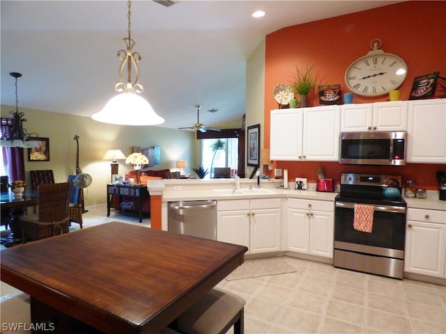 kitchen featuring white cabinets, stainless steel appliances, lofted ceiling, and pendant lighting