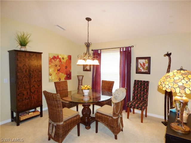 carpeted dining area with vaulted ceiling and a notable chandelier