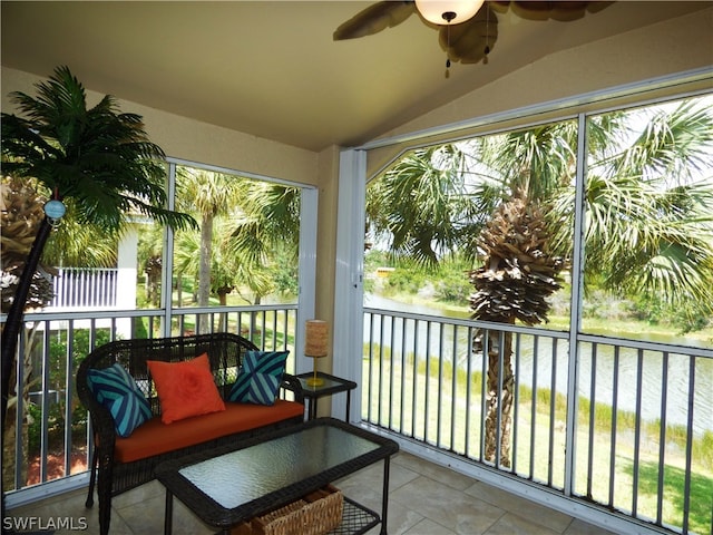 sunroom featuring a wealth of natural light, ceiling fan, a water view, and vaulted ceiling