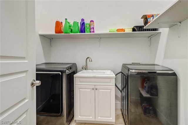 laundry room featuring sink, washer and dryer, light tile floors, and cabinets