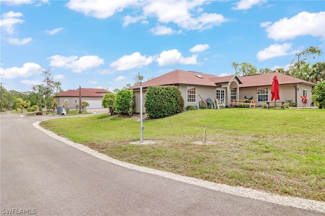 ranch-style home with a garage and a front lawn