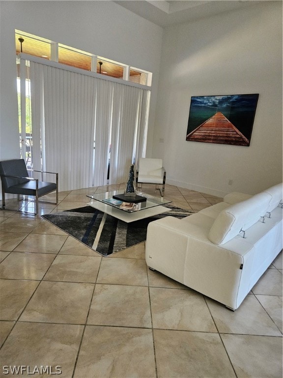 living room with a high ceiling and tile floors