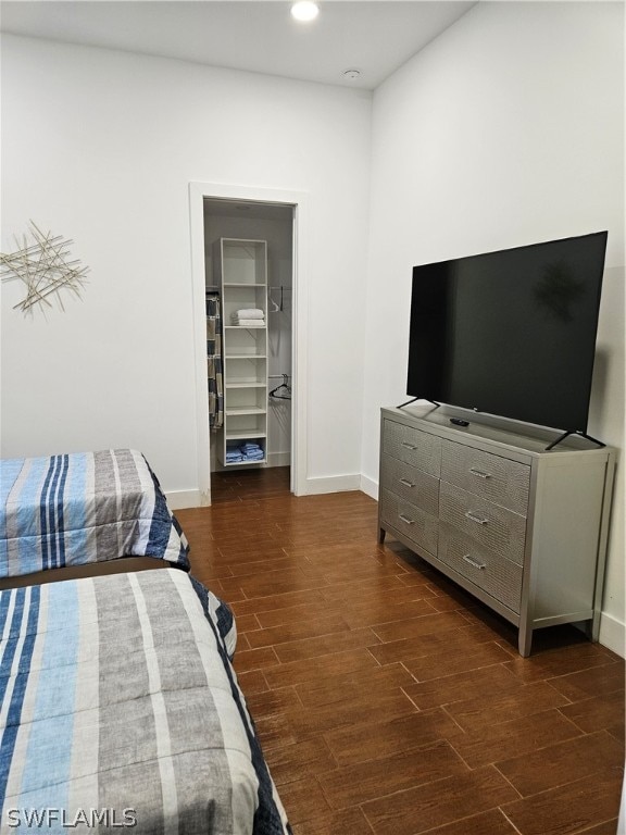 bedroom featuring a walk in closet, a closet, and dark hardwood / wood-style floors