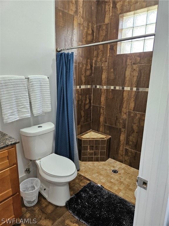 bathroom featuring walk in shower, vanity, toilet, and tile flooring