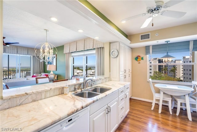 kitchen featuring hanging light fixtures, white cabinetry, sink, and wood-type flooring