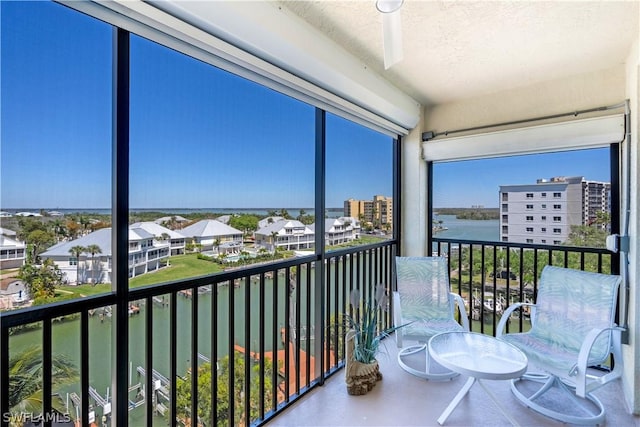 sunroom featuring a water view