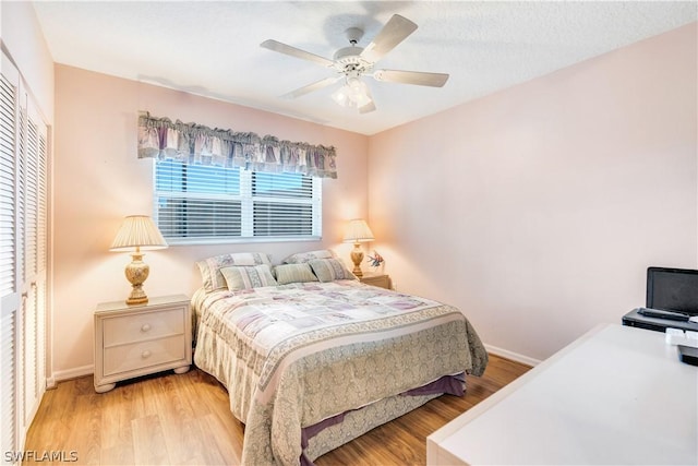 bedroom with ceiling fan, light wood-type flooring, a textured ceiling, and a closet