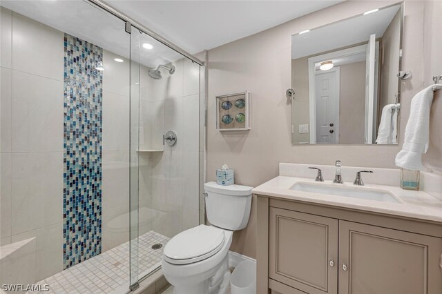 bathroom with toilet, an enclosed shower, and vanity