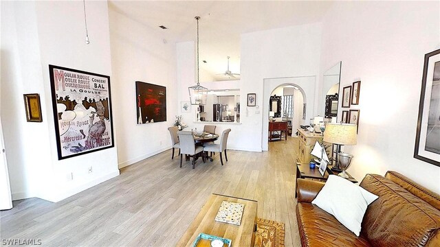 living room with light hardwood / wood-style flooring and a high ceiling