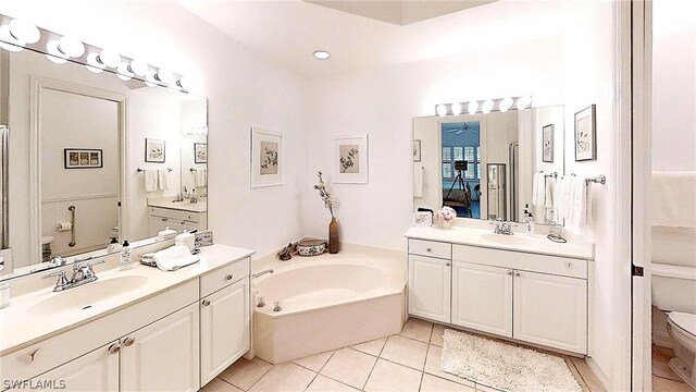 bathroom with vanity, a bath, tile patterned floors, and toilet