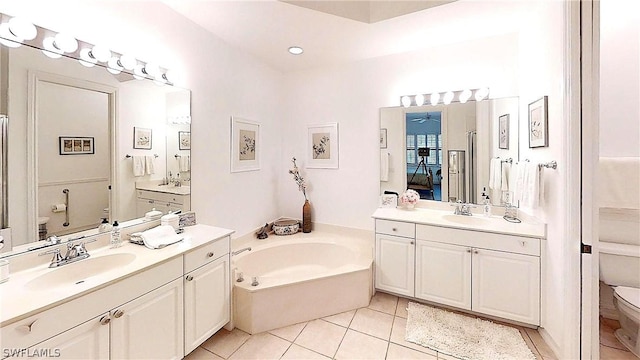 bathroom featuring tile patterned flooring, a garden tub, a sink, and toilet