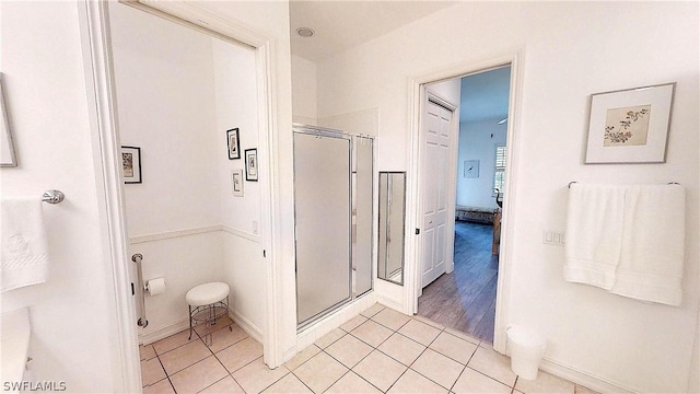 bathroom featuring a shower with shower door and tile patterned floors