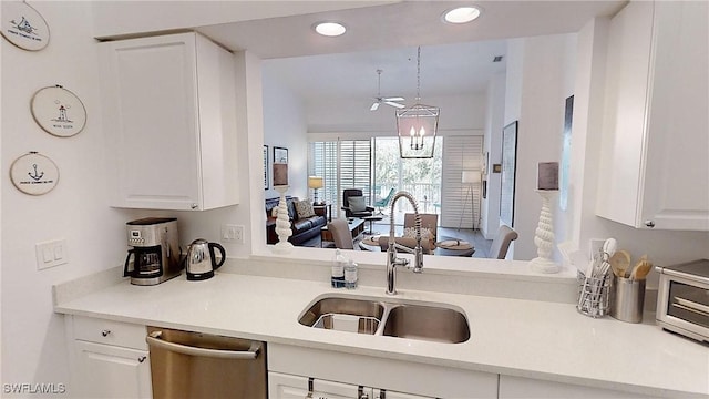 kitchen featuring sink, white cabinetry, decorative light fixtures, stainless steel dishwasher, and a chandelier