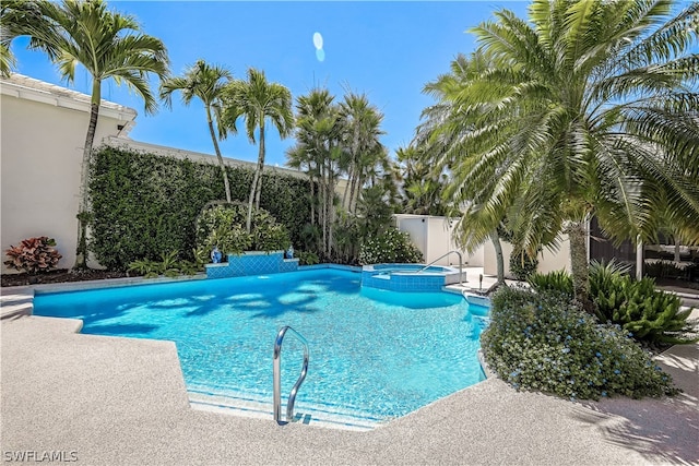 view of swimming pool featuring a patio area and an in ground hot tub