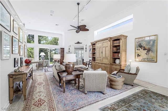 interior space with ceiling fan, track lighting, and a towering ceiling