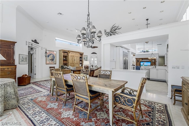 tiled dining area featuring ornamental molding, a high ceiling, and a chandelier