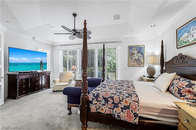 carpeted bedroom featuring ornamental molding, ceiling fan, and a tray ceiling