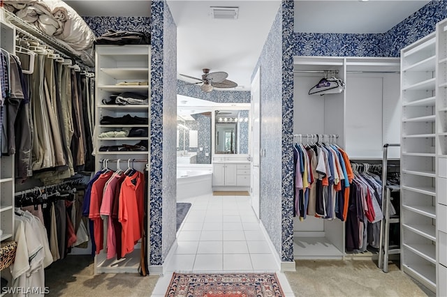 spacious closet with ceiling fan and light carpet