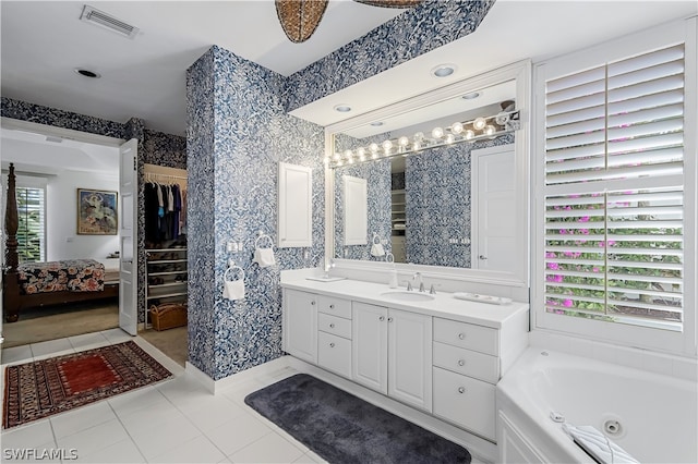 bathroom featuring a bathtub, vanity, and tile floors