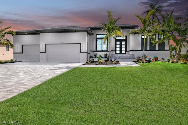 view of front of house with a garage and a lawn