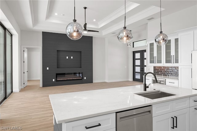 kitchen with light hardwood / wood-style flooring, white cabinets, a fireplace, and a tray ceiling