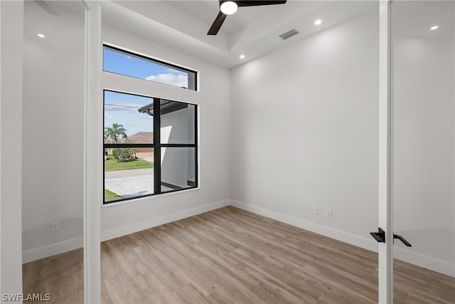 unfurnished room featuring a healthy amount of sunlight, light hardwood / wood-style floors, and ceiling fan