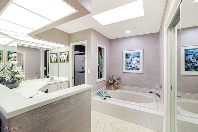 bathroom with vanity, a skylight, and shower with separate bathtub