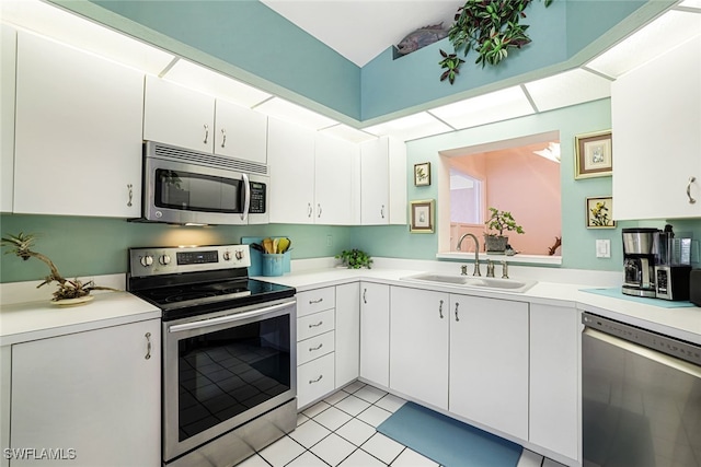 kitchen featuring white cabinetry, sink, light tile patterned floors, and stainless steel appliances