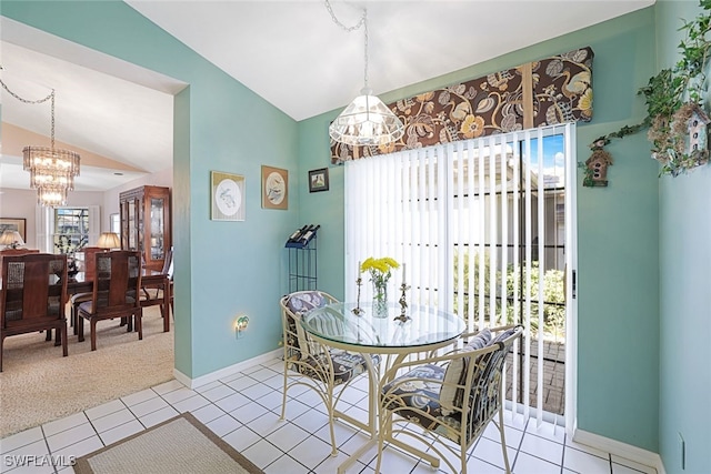 dining room featuring lofted ceiling, tile patterned flooring, and a notable chandelier