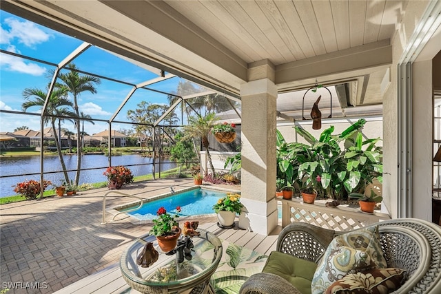 view of swimming pool with a water view, a patio area, and glass enclosure