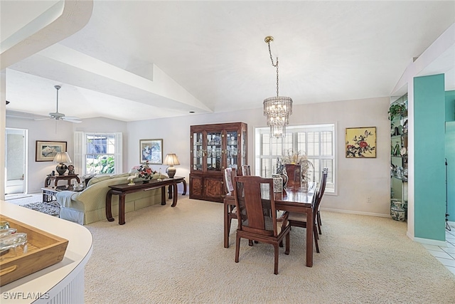 carpeted dining space with lofted ceiling and ceiling fan with notable chandelier