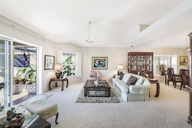 living room featuring ceiling fan, vaulted ceiling, and light carpet