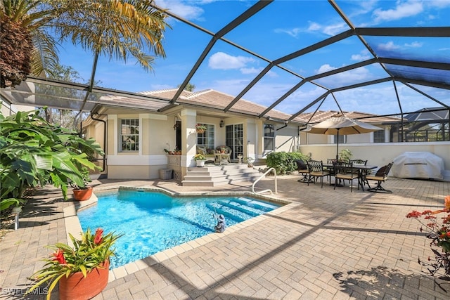 view of pool featuring grilling area, a patio area, and glass enclosure